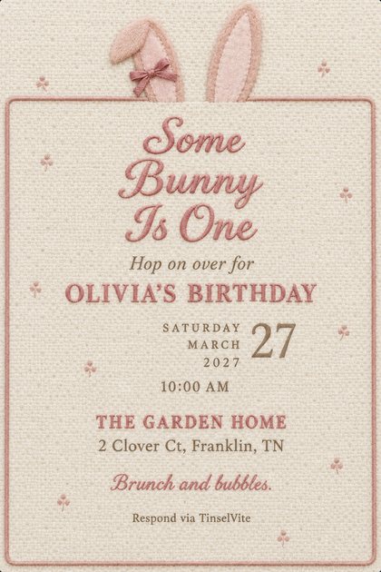 Cream wool bouclé first birthday invitation with blush bunny ears and a pink bow peeking over a rose piped frame, 'Some Bunny Is One' in pink script, with the date and venue below.